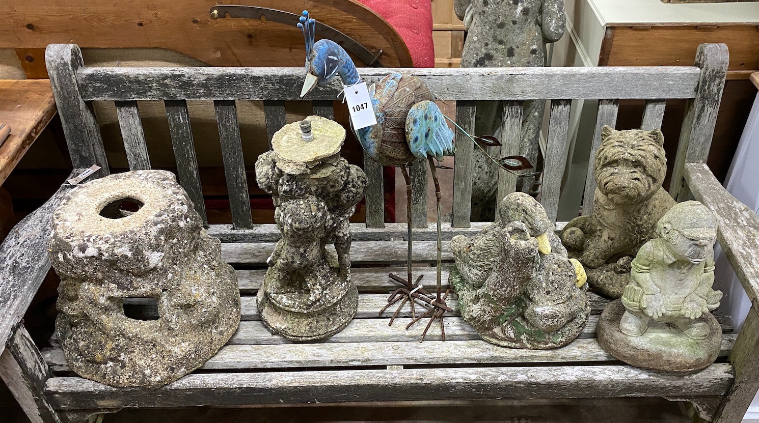 A group of four reconstituted stone garden ornaments and a painted metal peacock